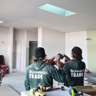 Two construction workers inspecting drills