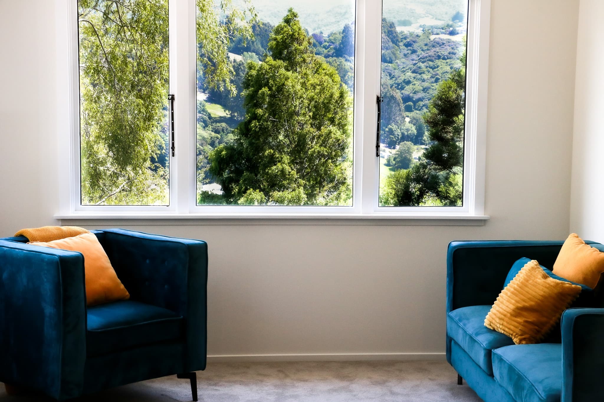 Blue two seater couch and single armchair in a newly renovated living space
.