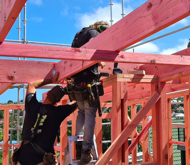 Two builders working on framing in a new build job site