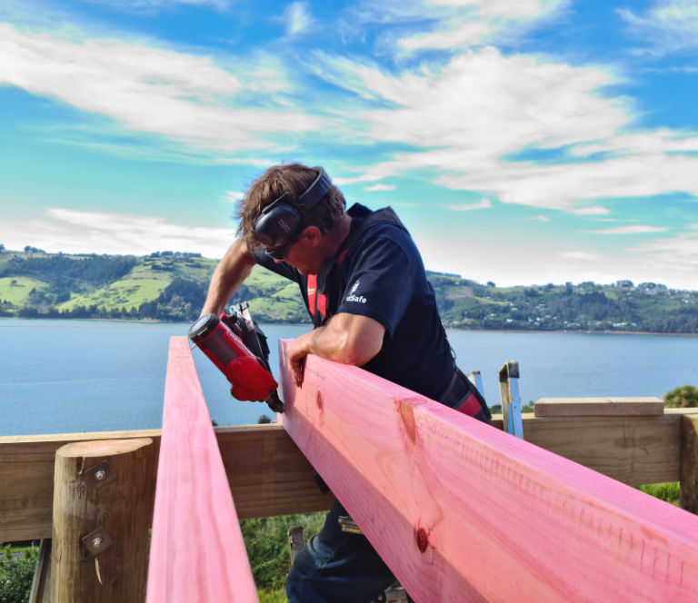 Build with a view, builder working on framing with ocean and harbour views in the background