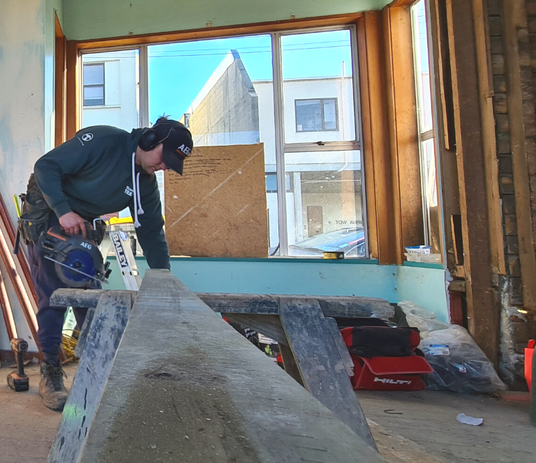 Builder working on timber in an extensive renovation of an older home