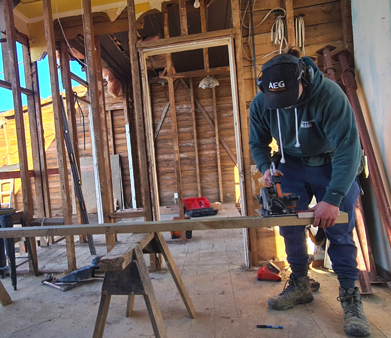 Builder working in construction site in old house