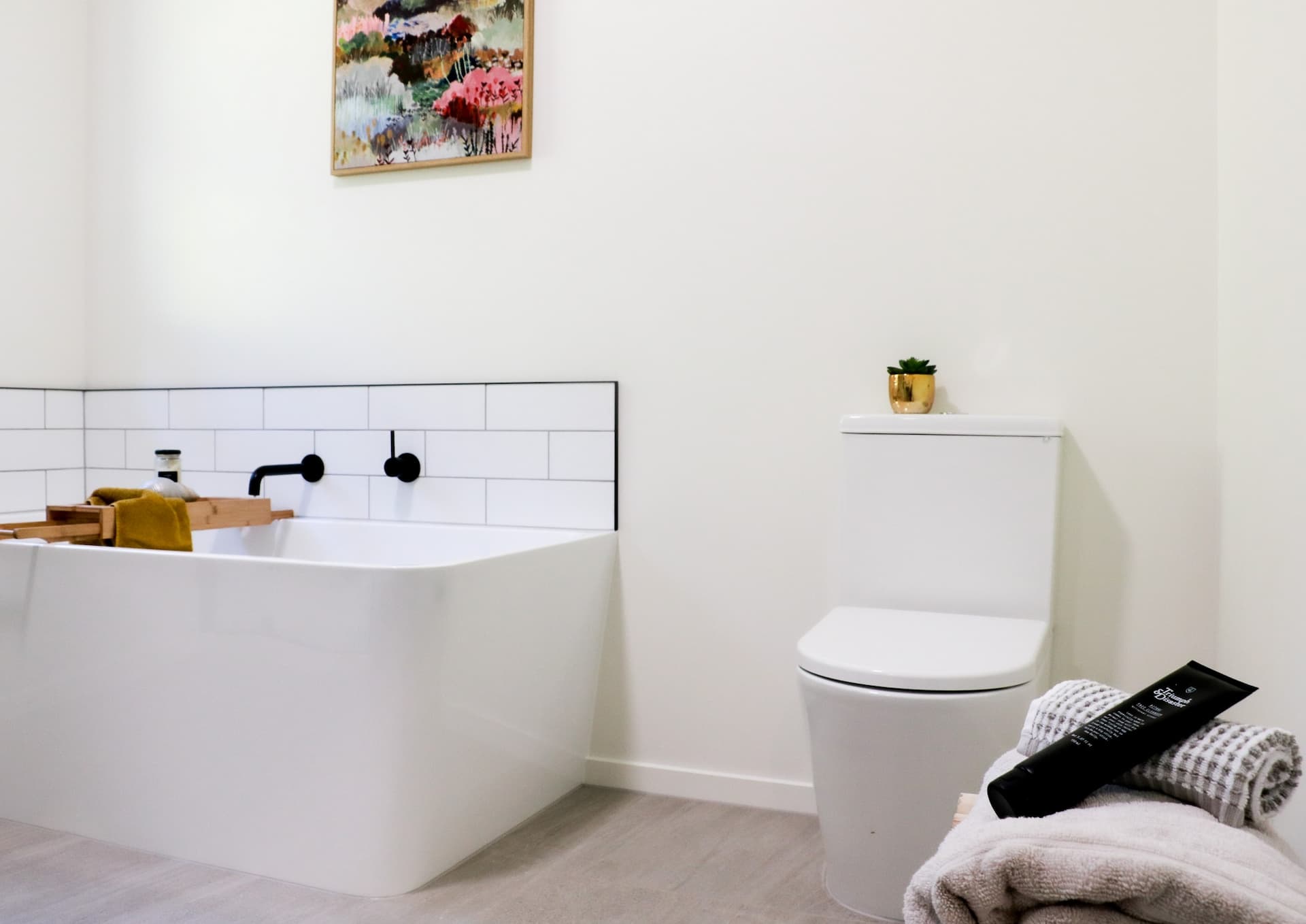 Newly renovated bathroom with white tub, toilet and subway tiles